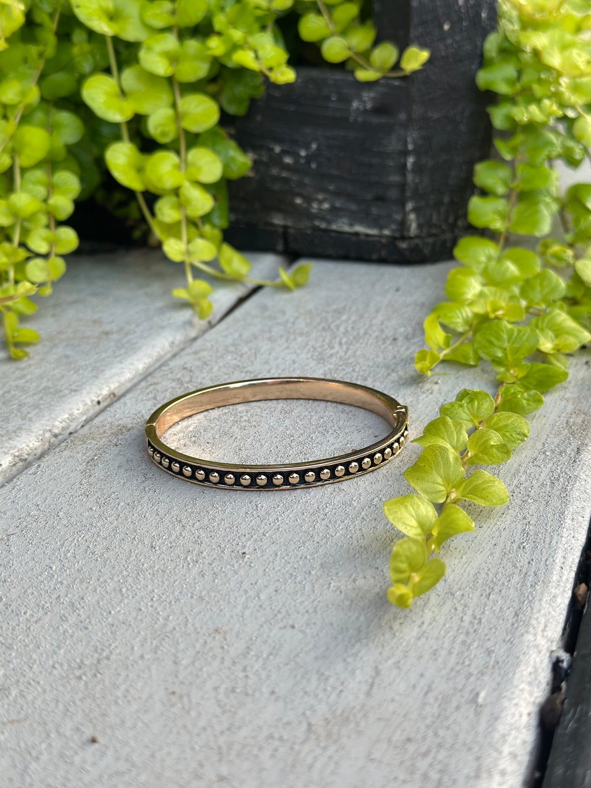 Gold bangle with black and gold bead detail