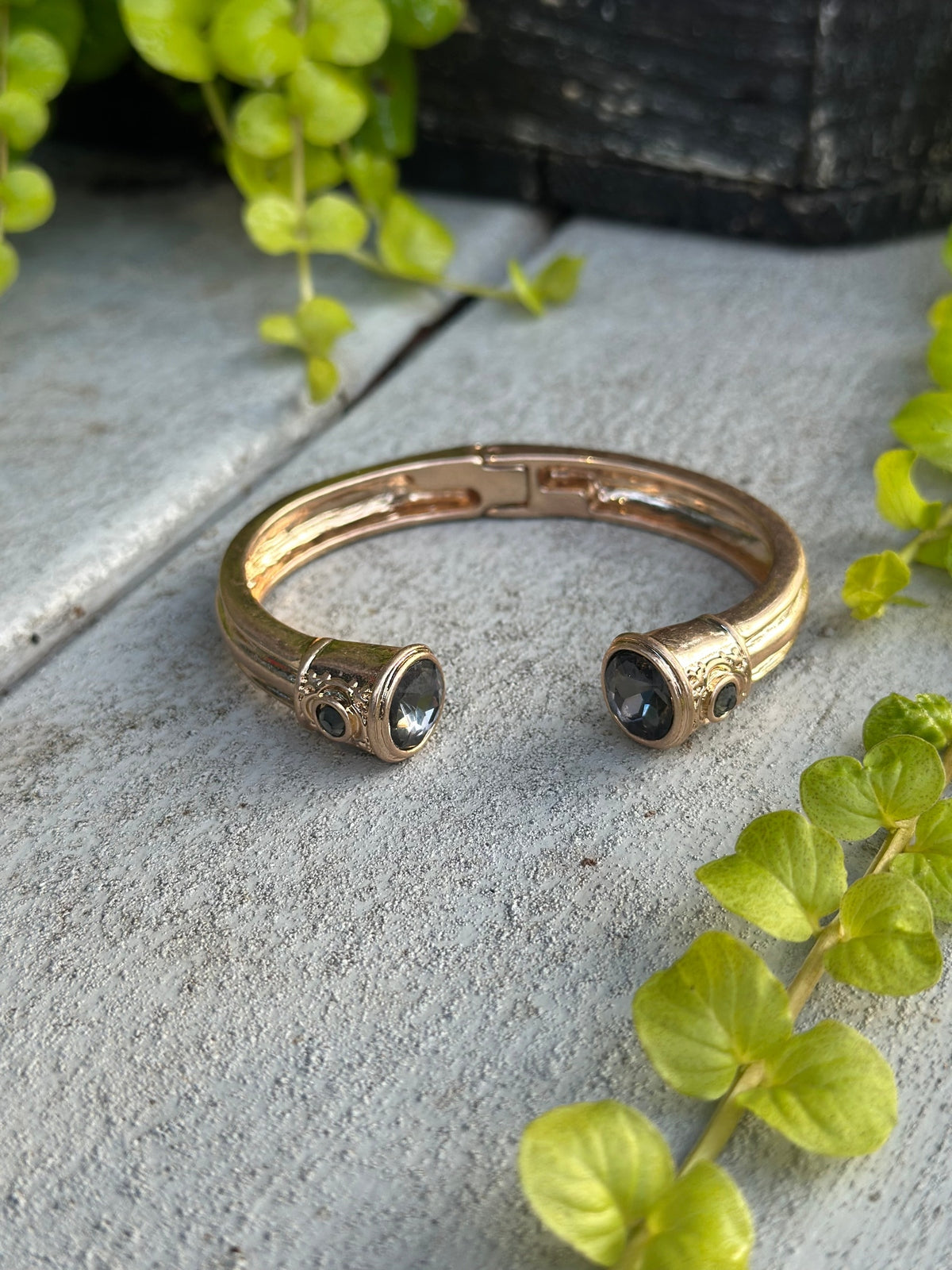 Gold cuff bangle with a dark gemstone