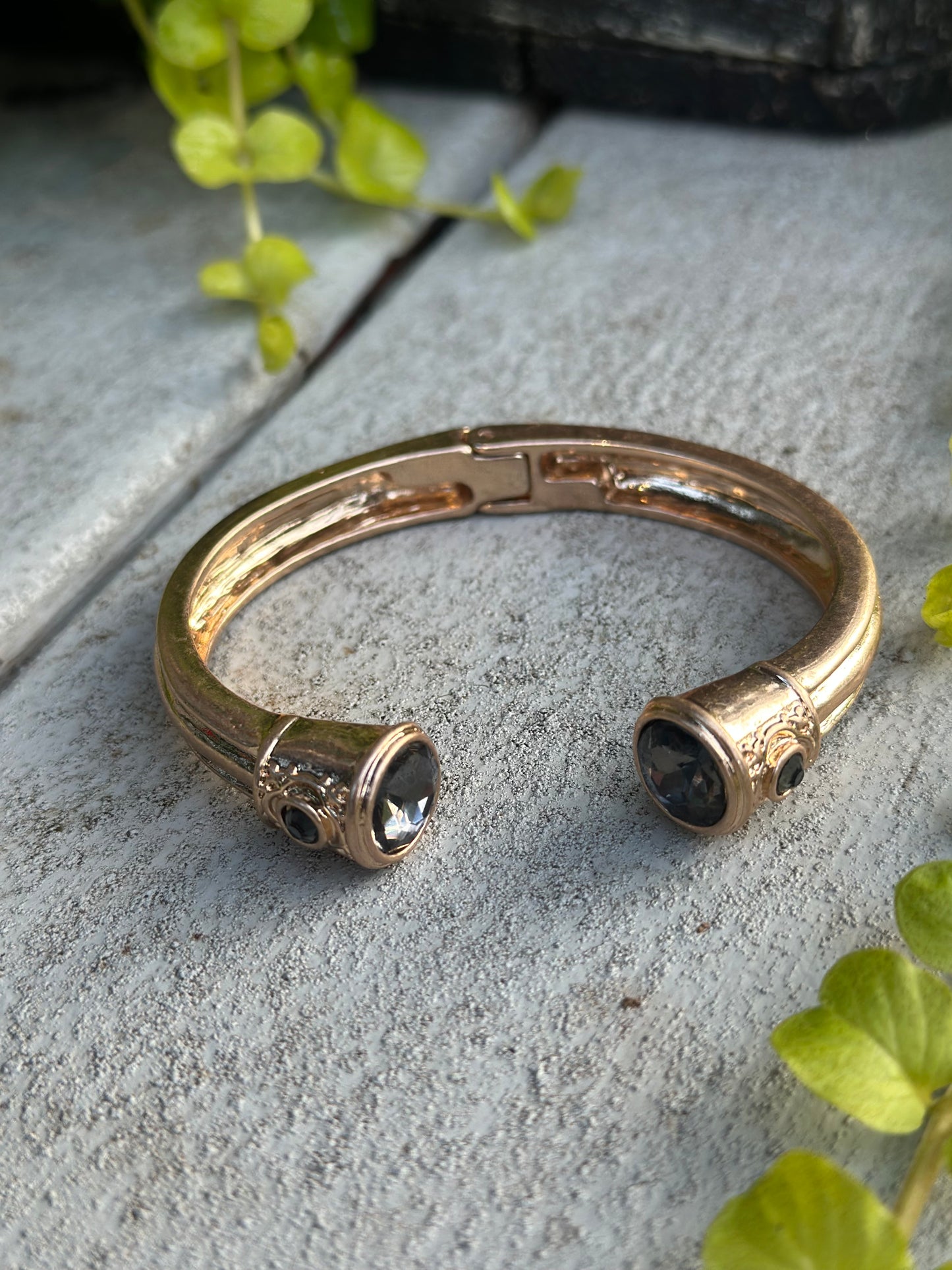 Gold cuff bangle with a dark gemstone