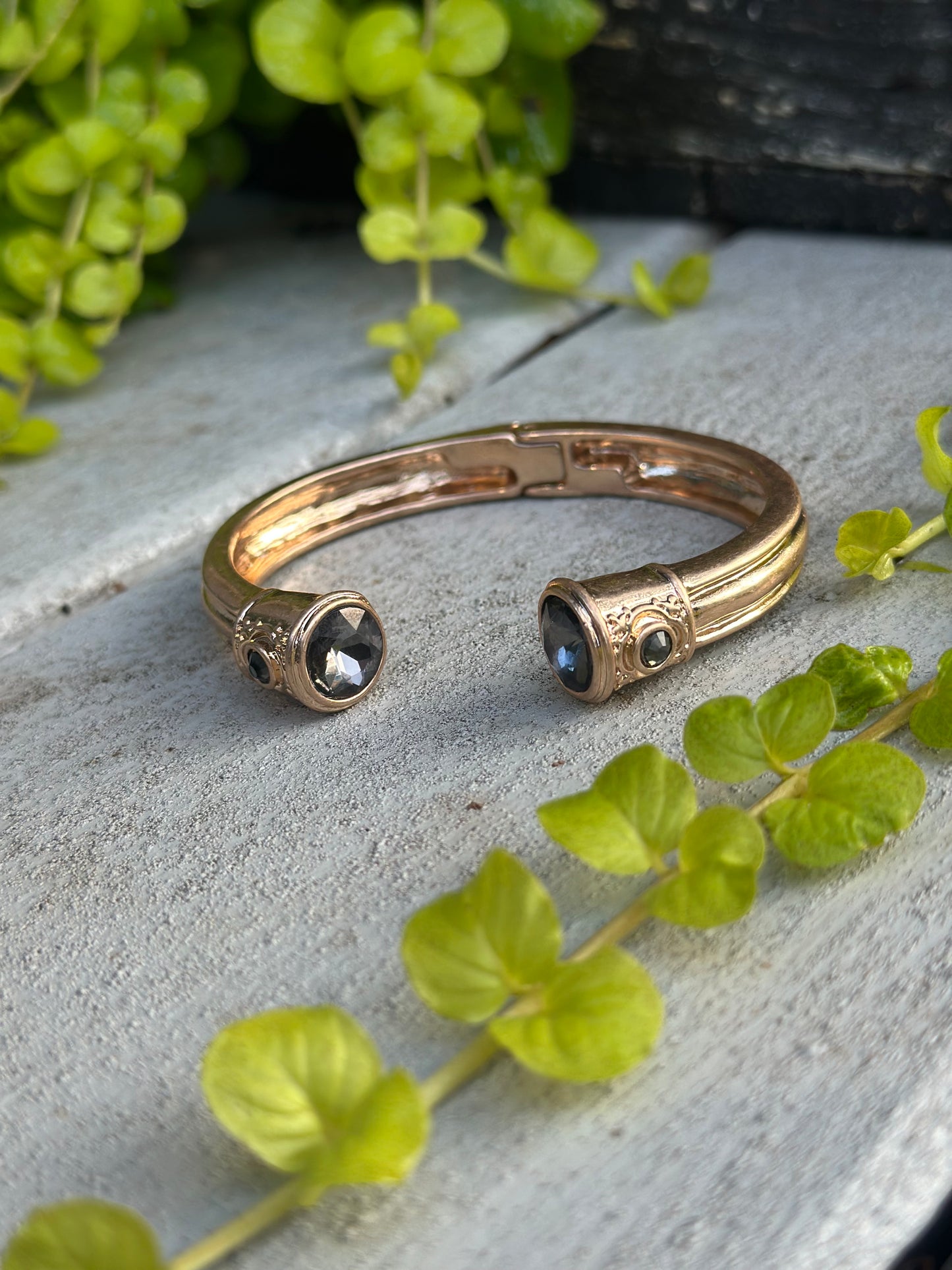 Gold cuff bangle with a dark gemstone