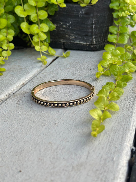 Gold bangle with black and gold bead detail